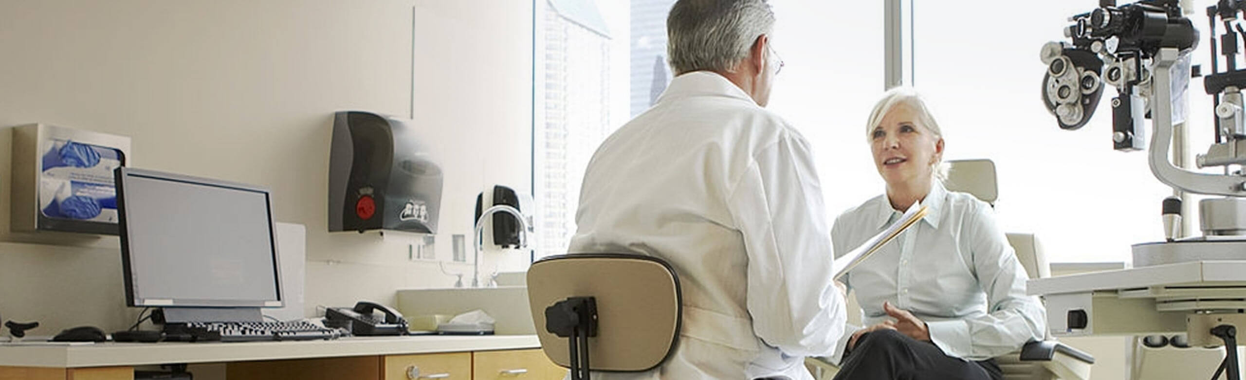 Eye doctor and patient speaking in exam room