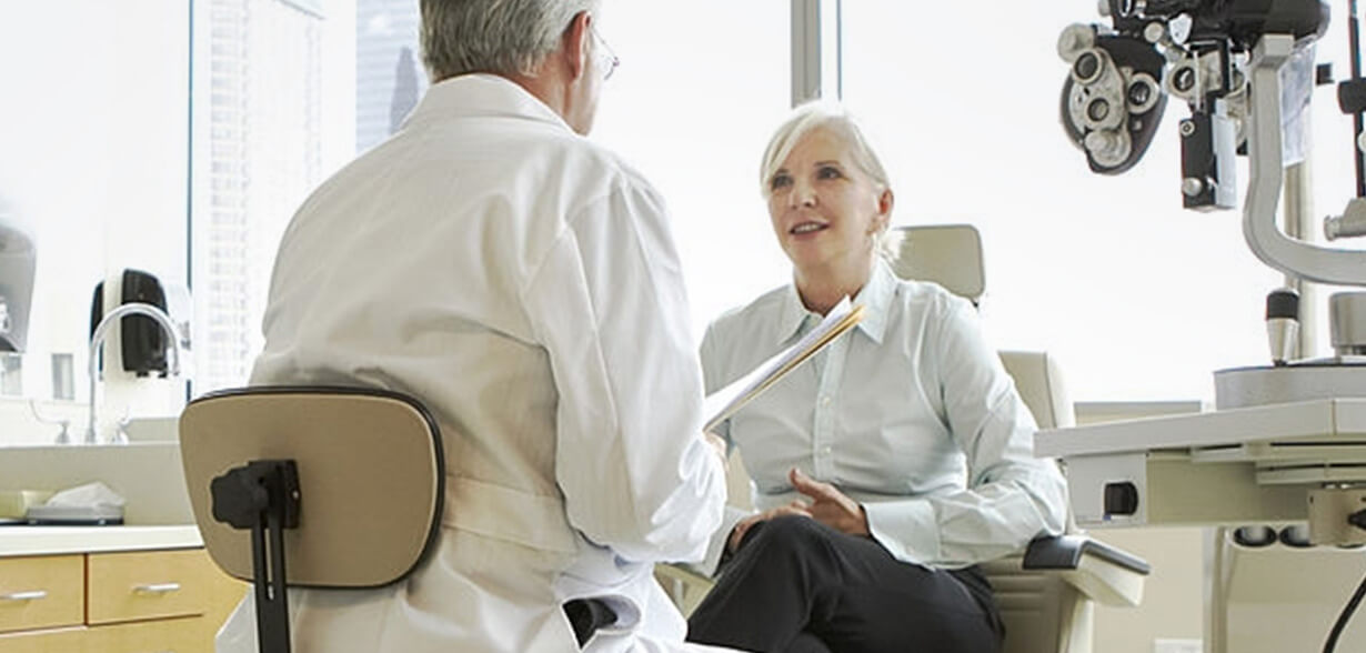 Eye doctor and patient speaking in exam room